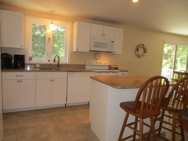 4 Stage Coach Road Harwich, MA 02645 - Photo 7 of 34 a kitchen with stainless steel appliances granite countertop a sink a stove a dining table and chairs