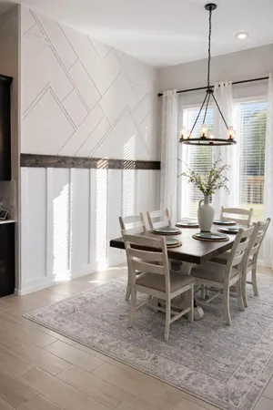 a dining room with wooden floor and a chandelier