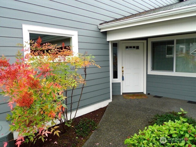 160 East Soderberg Road, Unit H23 Allyn, WA 98524 - Photo 1 of 20 a view of yellow house with a flower garden