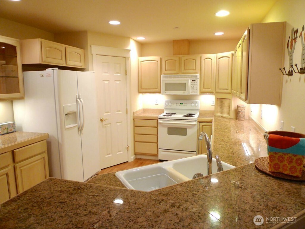160 East Soderberg Road, Unit H23 Allyn, WA 98524 - Photo 4 of 20 a kitchen with stainless steel appliances granite countertop a sink stove and refrigerator