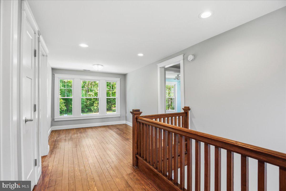 16146 Thomas Road Piney Point, MD 20674 - Photo 36 of 70 a view of hallway with wooden floor and stairs