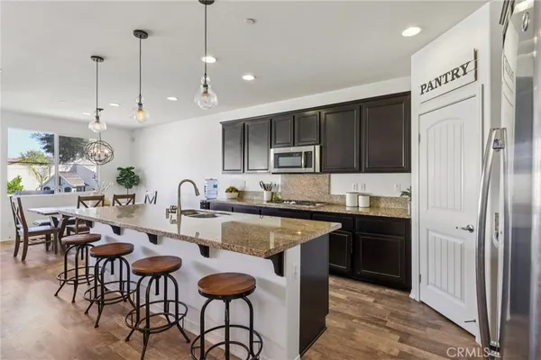 a kitchen with granite countertop kitchen island stainless steel appliances a sink a stove and a center island