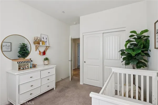 a bedroom with a bed and dresser with mirror