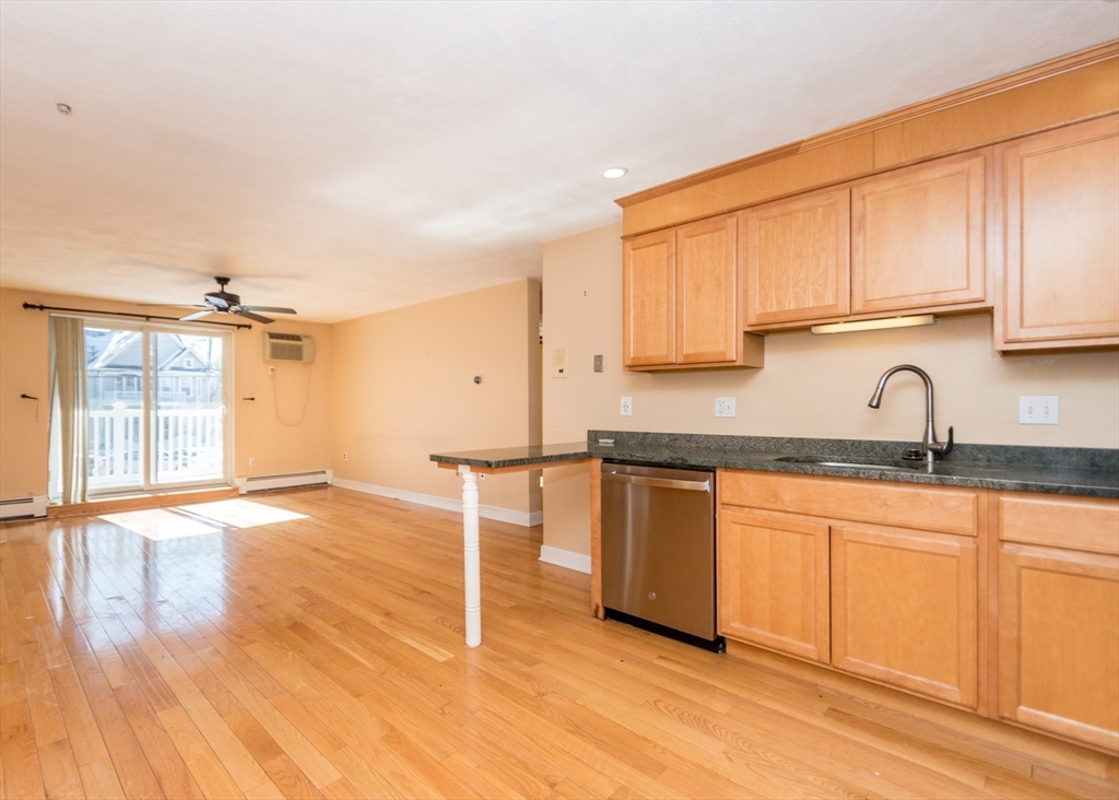 99 Pleasant Street, Unit 11 Watertown, MA 02472 - Photo 2 of 22 a kitchen with granite countertop a sink cabinets and wooden floor