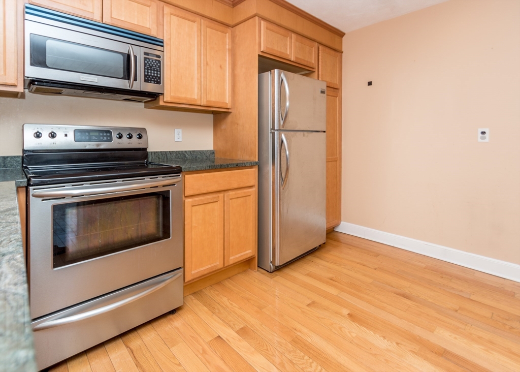 99 Pleasant Street, Unit 11 Watertown, MA 02472 - Photo 4 of 22 a kitchen with a stove microwave and refrigerator