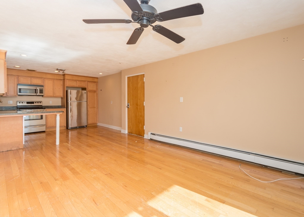 99 Pleasant Street, Unit 11 Watertown, MA 02472 - Photo 6 of 22 a view of a kitchen with a stove cabinets and wooden floor