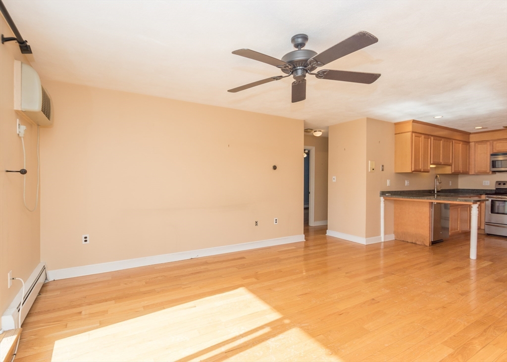 99 Pleasant Street, Unit 11 Watertown, MA 02472 - Photo 7 of 22 a view of a kitchen with a sink and a refrigerator