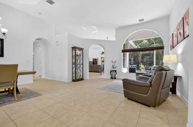 a kitchen with stainless steel appliances a refrigerator a stove a sink cabinets and a dining table