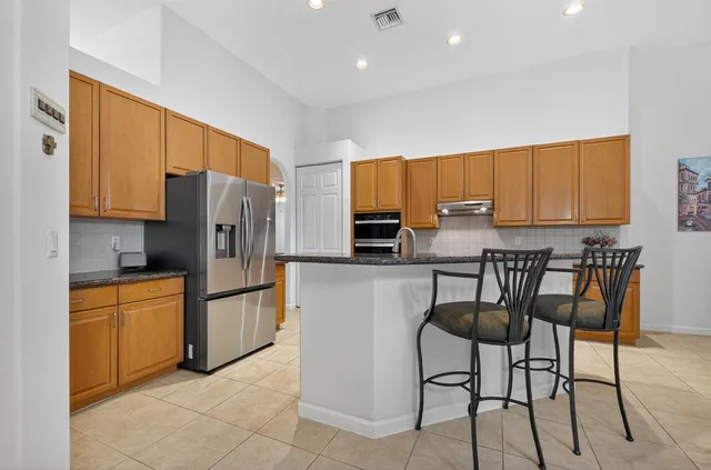 a kitchen with stainless steel appliances granite countertop a refrigerator and cabinets