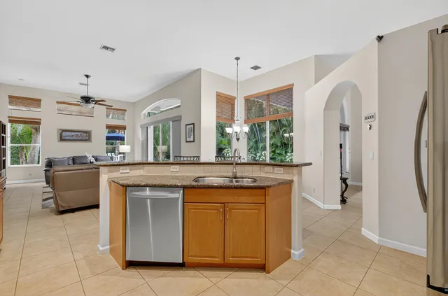 a kitchen with granite countertop a sink a stove and cabinets