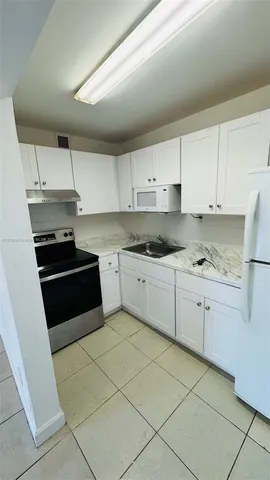 a kitchen with granite countertop white cabinets and black appliances