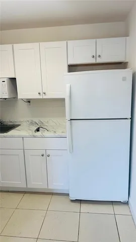 a kitchen with cabinets and a refrigerator