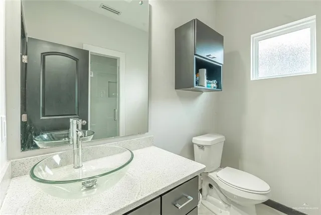 a bathroom with a toilet a sink and mirror