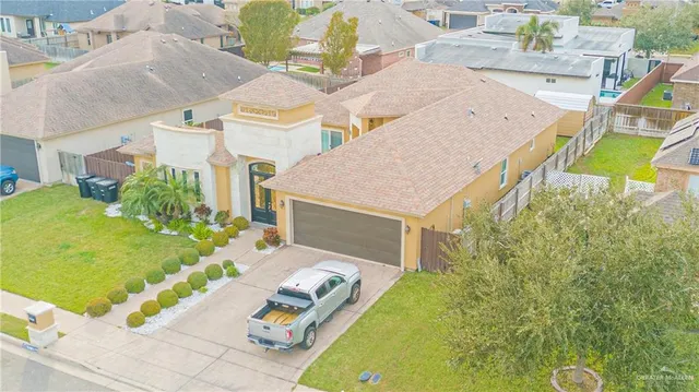 a aerial view of a house with swimming pool and large trees