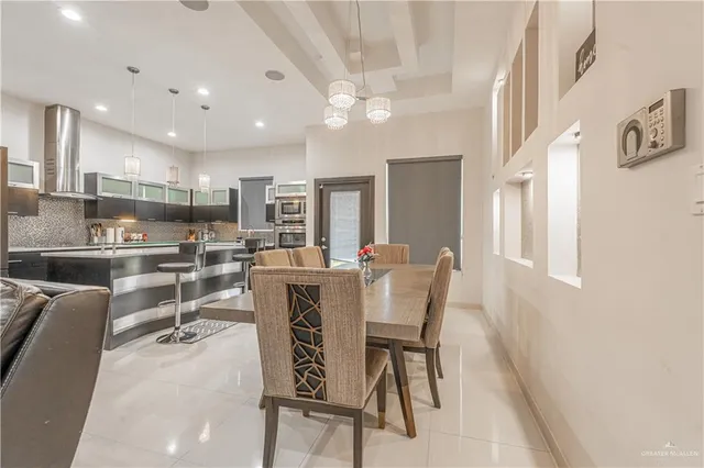 a dining room with kitchen island furniture a chandelier and kitchen view