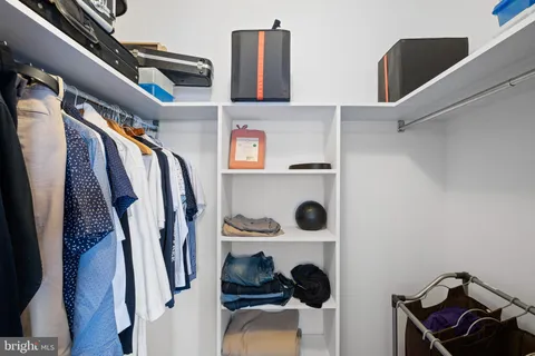 a view of walk in closet with clothes and shoes