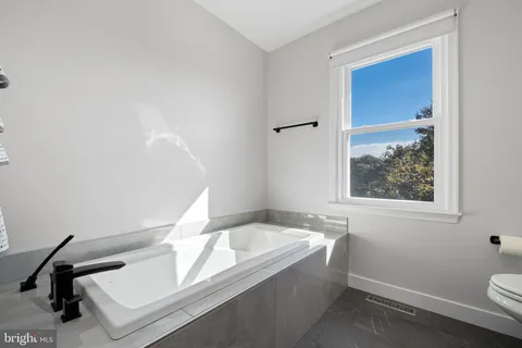 a bathroom with a bathtub and a window