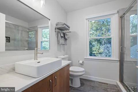 a bathroom with a sink toilet and a window