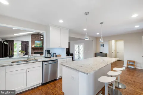 a kitchen with a stove a sink a dining table and chairs