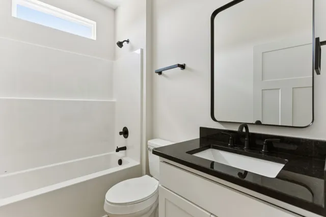 a bathroom with a granite countertop sink toilet and shower