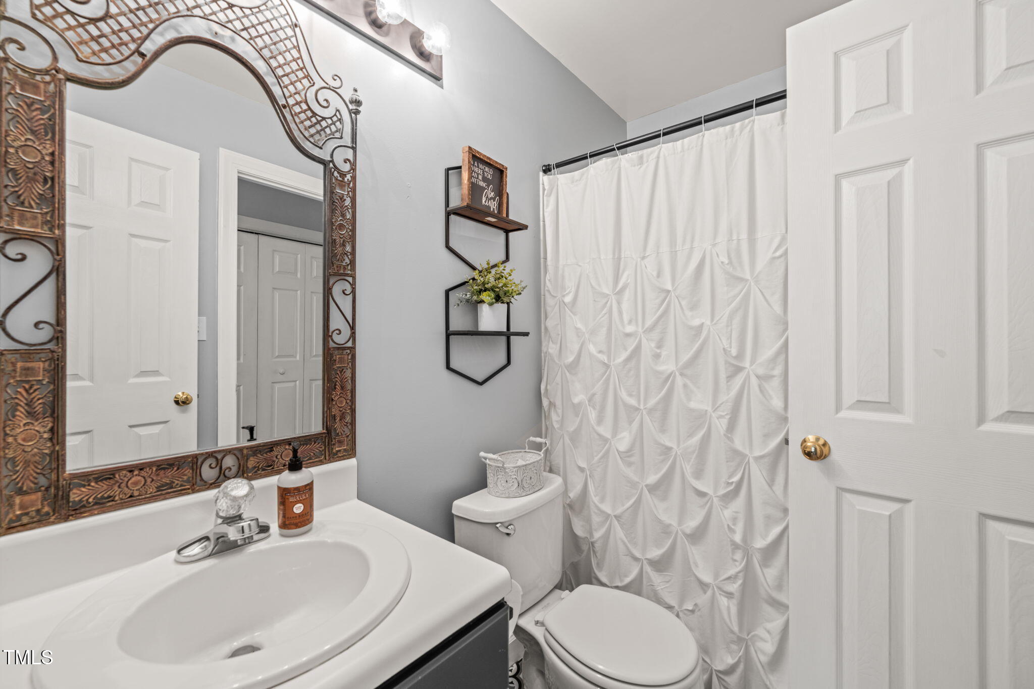 2102 Trailridge Court Raleigh, NC 27603 - Photo 7 of 28 a bathroom with a sink a toilet and a mirror