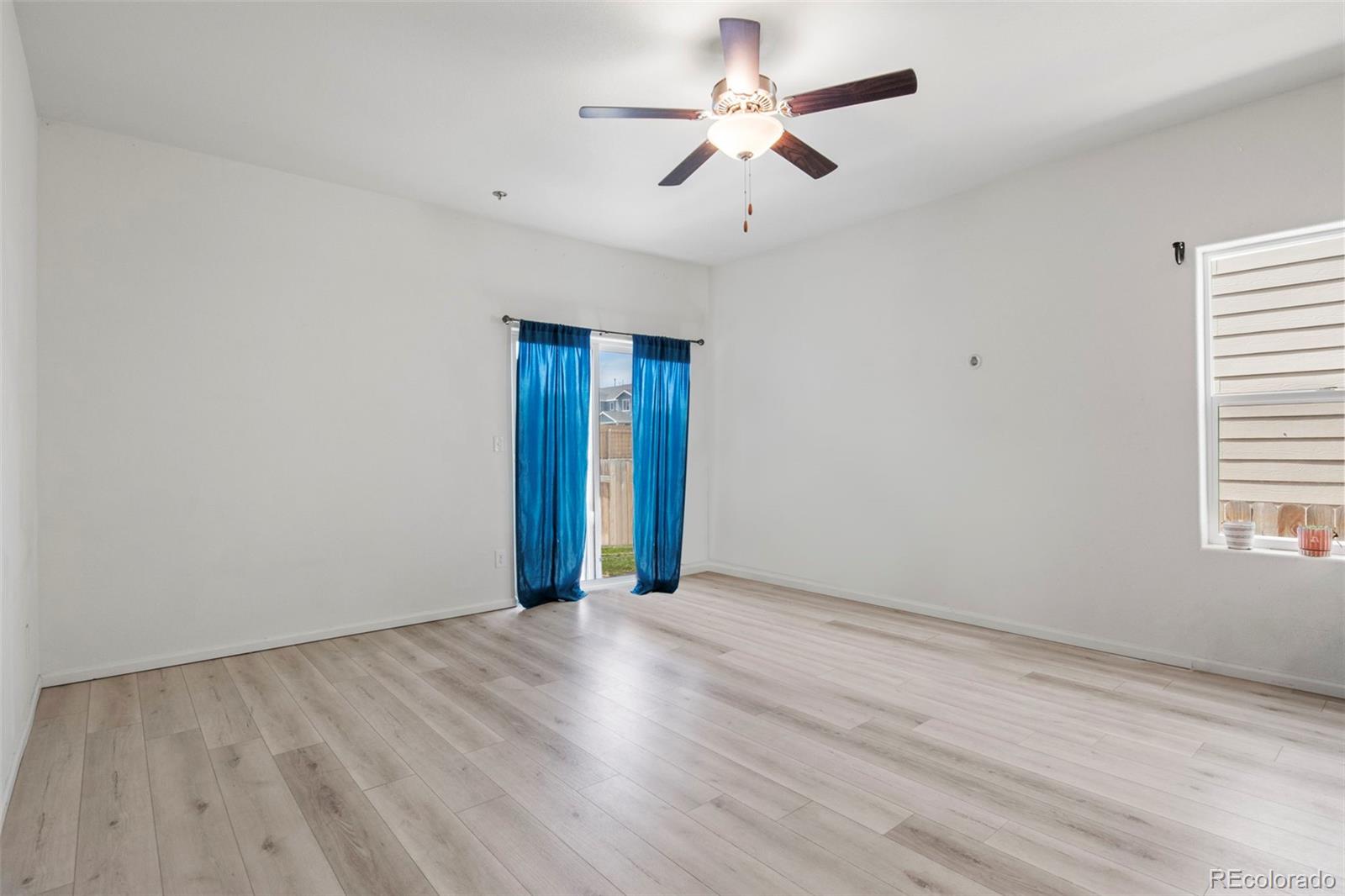 311 Maple Street Bennett, CO 80102 - Photo 15 of 35 an empty room with wooden floor and windows