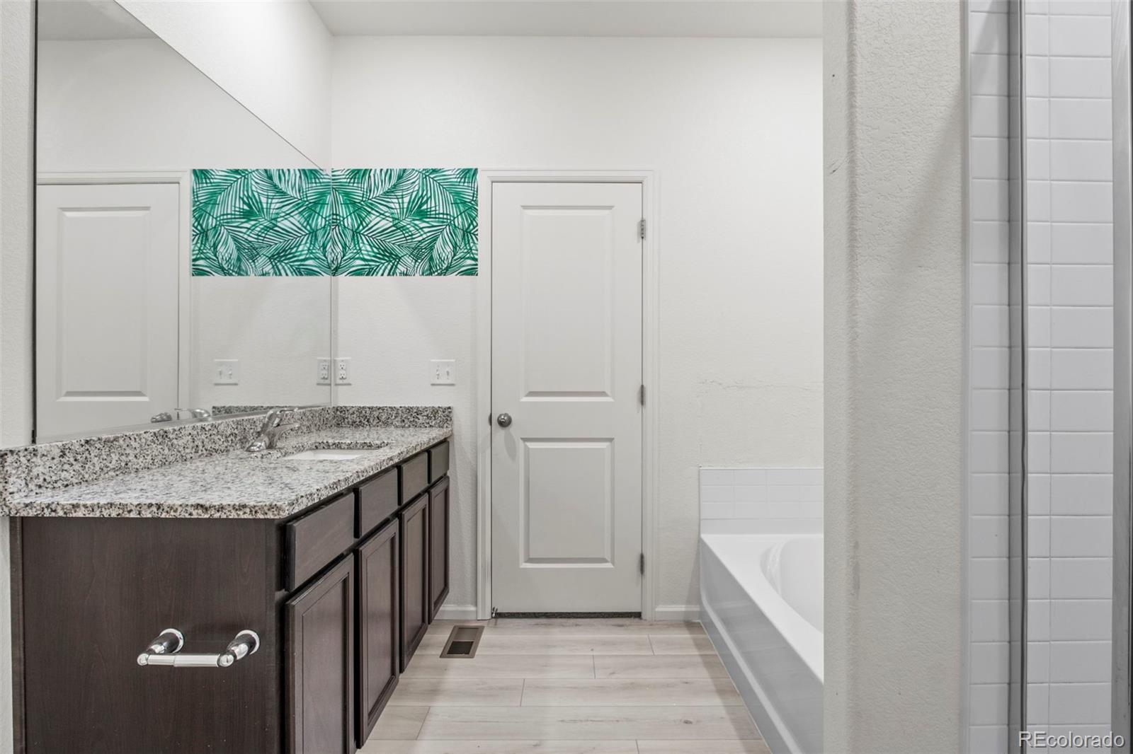 311 Maple Street Bennett, CO 80102 - Photo 24 of 35 a bathroom with a granite countertop sink and a mirror