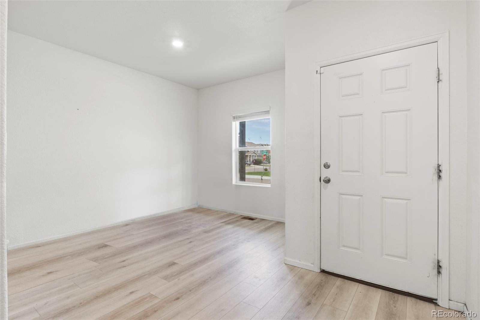 311 Maple Street Bennett, CO 80102 - Photo 7 of 35 a view of an empty room with wooden floor