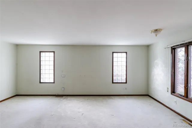 an empty room with windows and closet