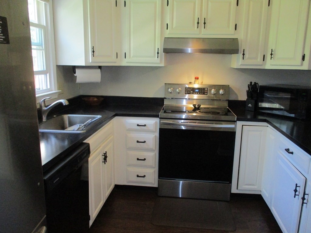 2 Tuck Farm Road, Unit 5 Auburn, MA 01501 - Photo 5 of 11 a kitchen with a stove and white cabinets
