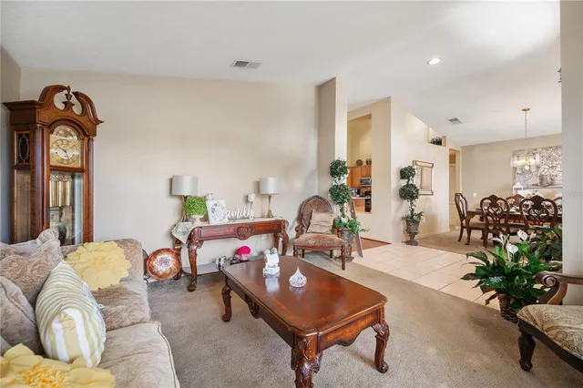 a living room with furniture a chandelier and a window