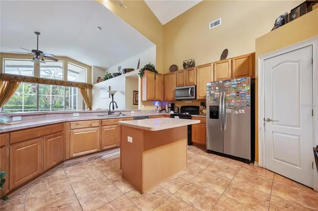 a kitchen with stainless steel appliances granite countertop a refrigerator and a stove top oven