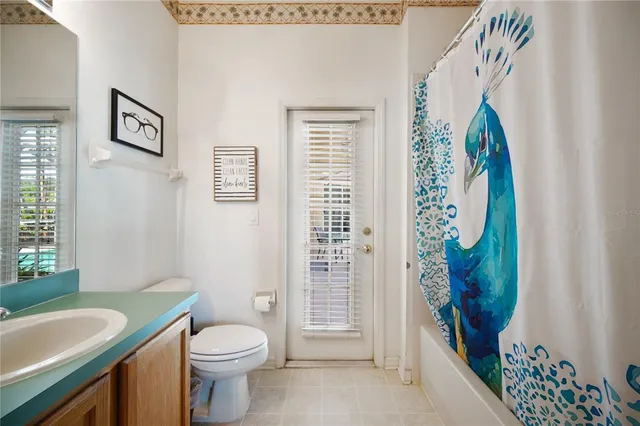 a bathroom with a sink a toilet and shower curtain