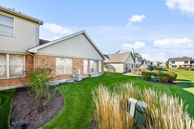 a very nice looking house with a big yard and potted plants