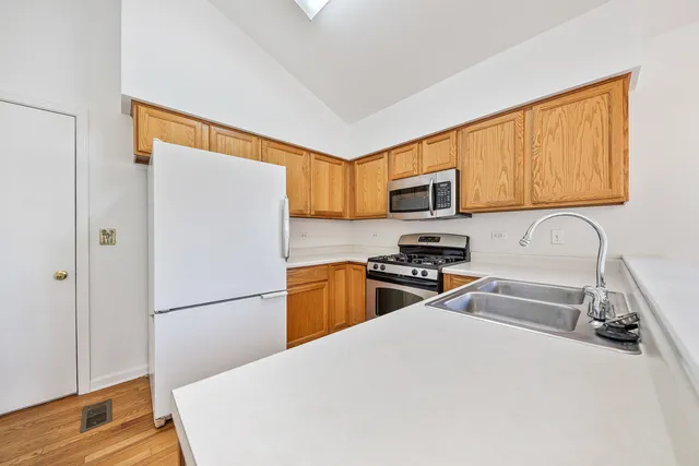 a kitchen with granite countertop a refrigerator stove top oven and sink