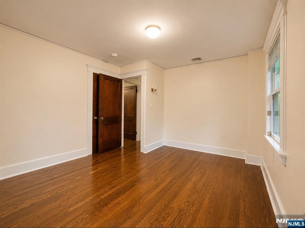 84 Valley View Avenue Ridgewood, NJ 07450 - Photo 13 of 20 an empty room with wooden floor and windows
