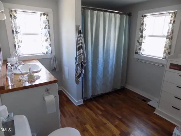 a kitchen with stainless steel appliances a wooden floor and a window