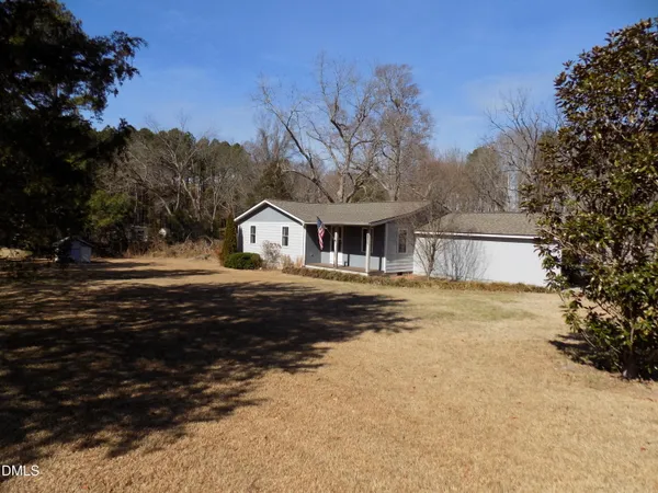 a front view of house with yard and trees around