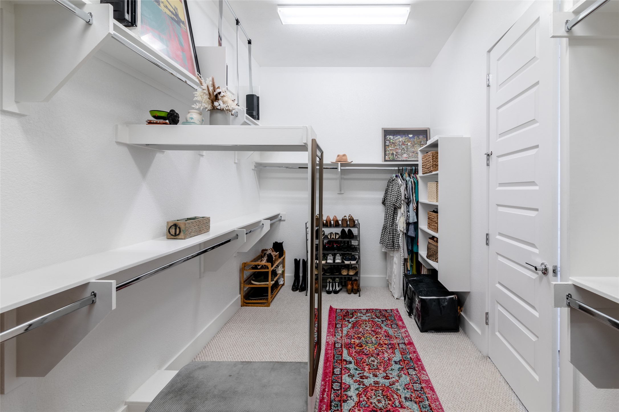 6025 Seville Drive Austin, TX 78724 - Photo 20 of 40 1 of 2 spacious primary walk-in closet featuring built-in shelving, multiple hanging rods