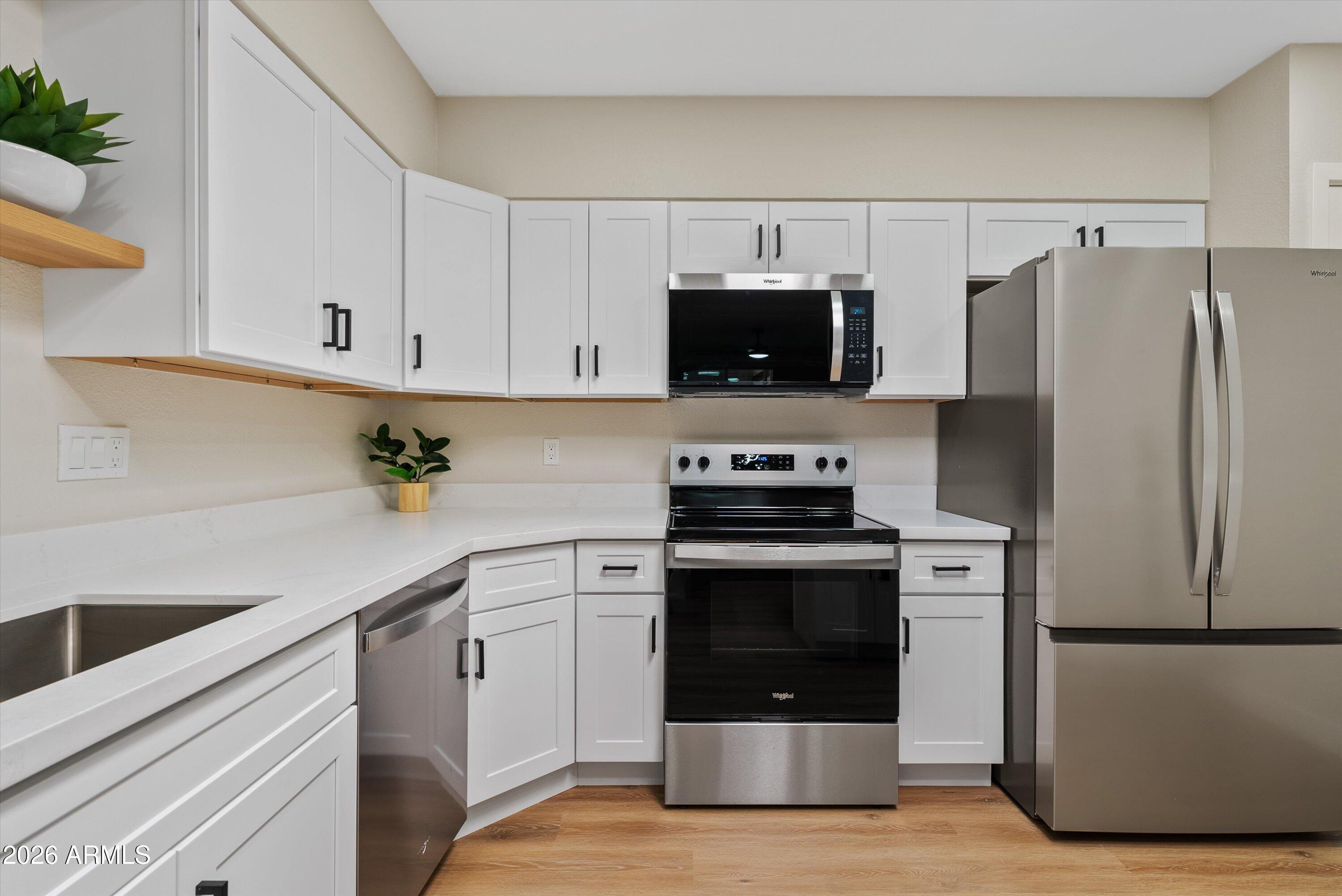 720 South Dobson Road, Unit 55 Mesa, AZ 85202 - Photo 10 of 33 a kitchen with white cabinets and stainless steel appliances