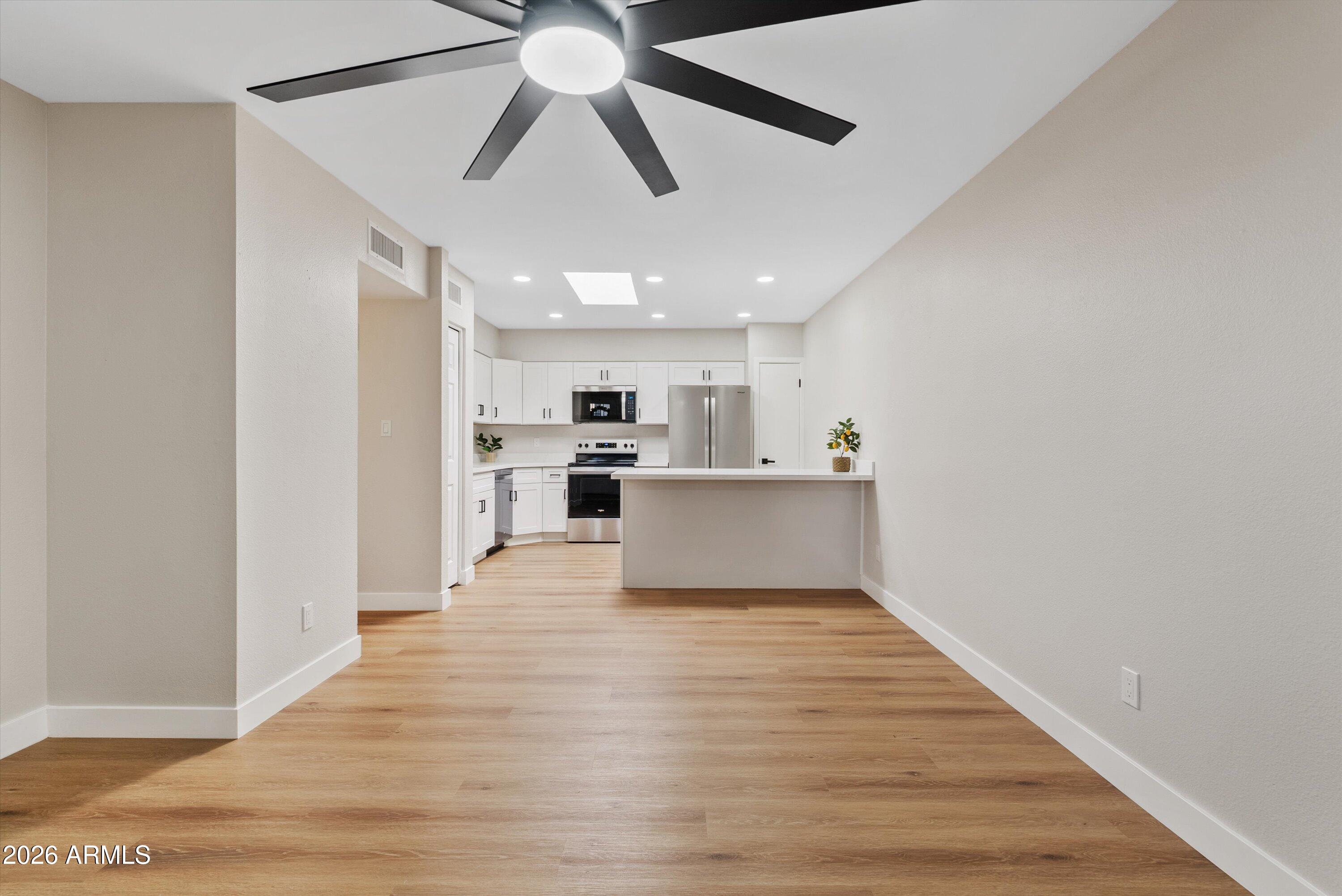 720 South Dobson Road, Unit 55 Mesa, AZ 85202 - Photo 4 of 33 a view of empty room with wooden floor and kitchen view