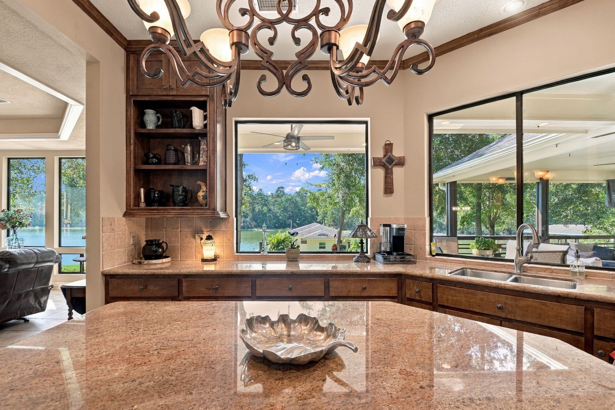 20341 Bay Hill Road Point Blank, TX 77364 - Photo 8 of 50 Experience stunning lake views from this elegant kitchen, featuring granite countertops, warm wood cabinetry, and ample natural light through large windows.