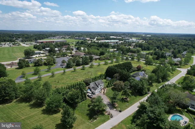 an aerial view of residential houses with outdoor space and trees