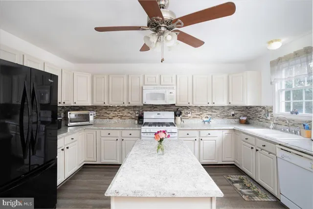 a kitchen with granite countertop a sink stainless steel appliances and cabinets