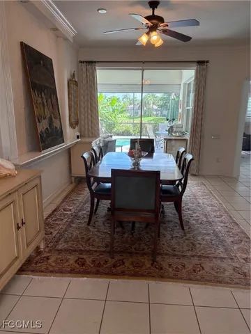 a dining room with chandelier fan and wooden floor