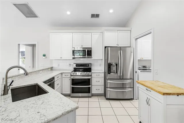 a kitchen with white cabinets and stainless steel appliances