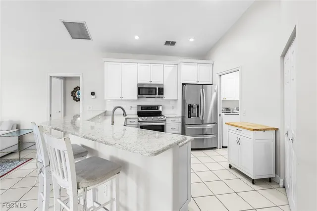 a kitchen with a refrigerator a stove a sink dishwasher and wooden cabinets with wooden floor