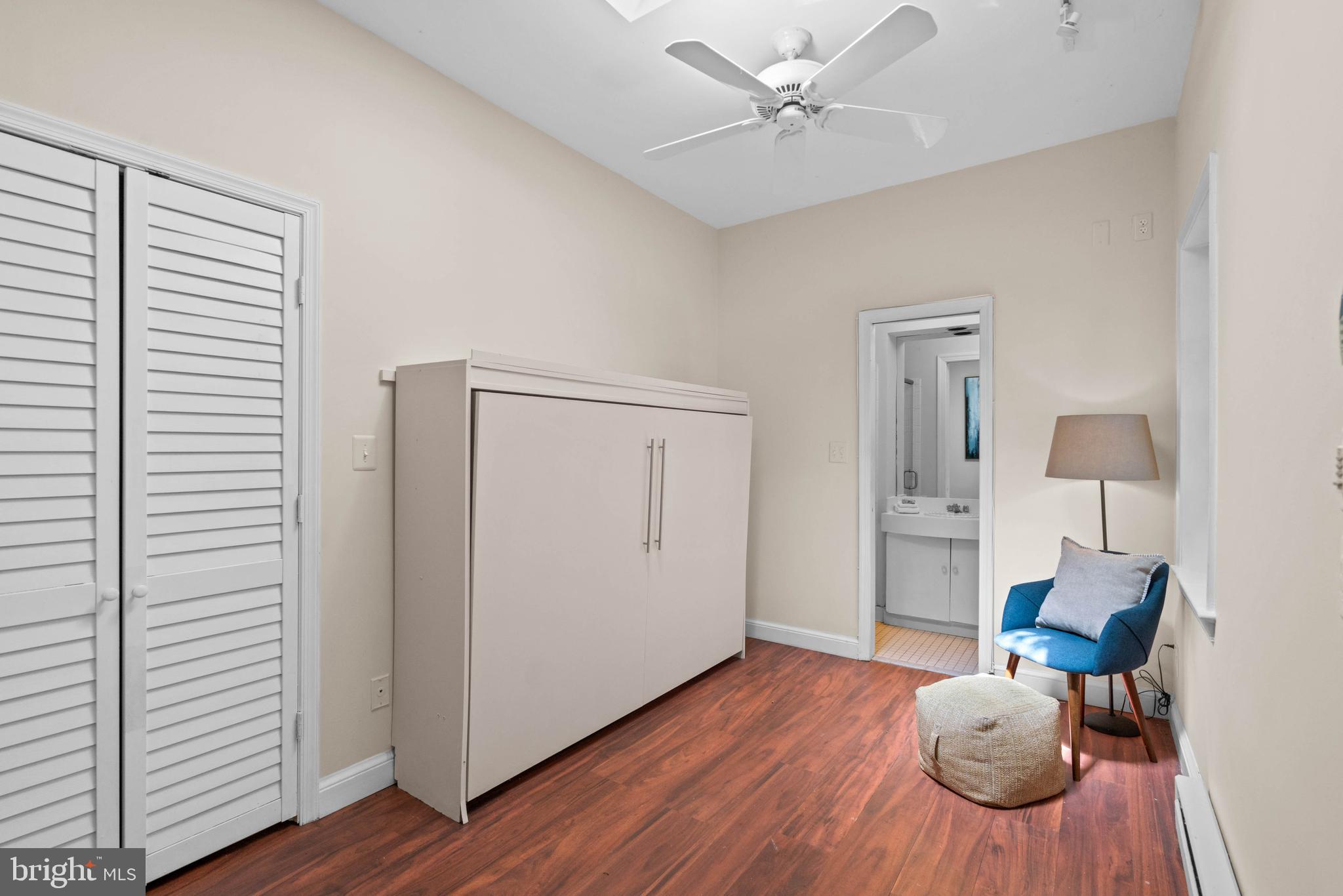 1406 34th Street Northwest Washington, DC 20007 - Photo 42 of 45 a view of a livingroom with wooden floor a ceiling fan and a window