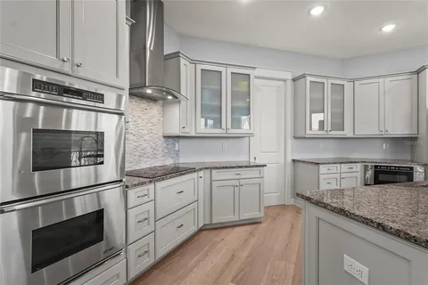 a bathroom with a granite countertop sink a toilet and a large mirror