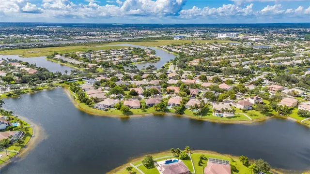 a kitchen with stainless steel appliances kitchen island granite countertop a sink a stove a dining table and chairs with wooden floor